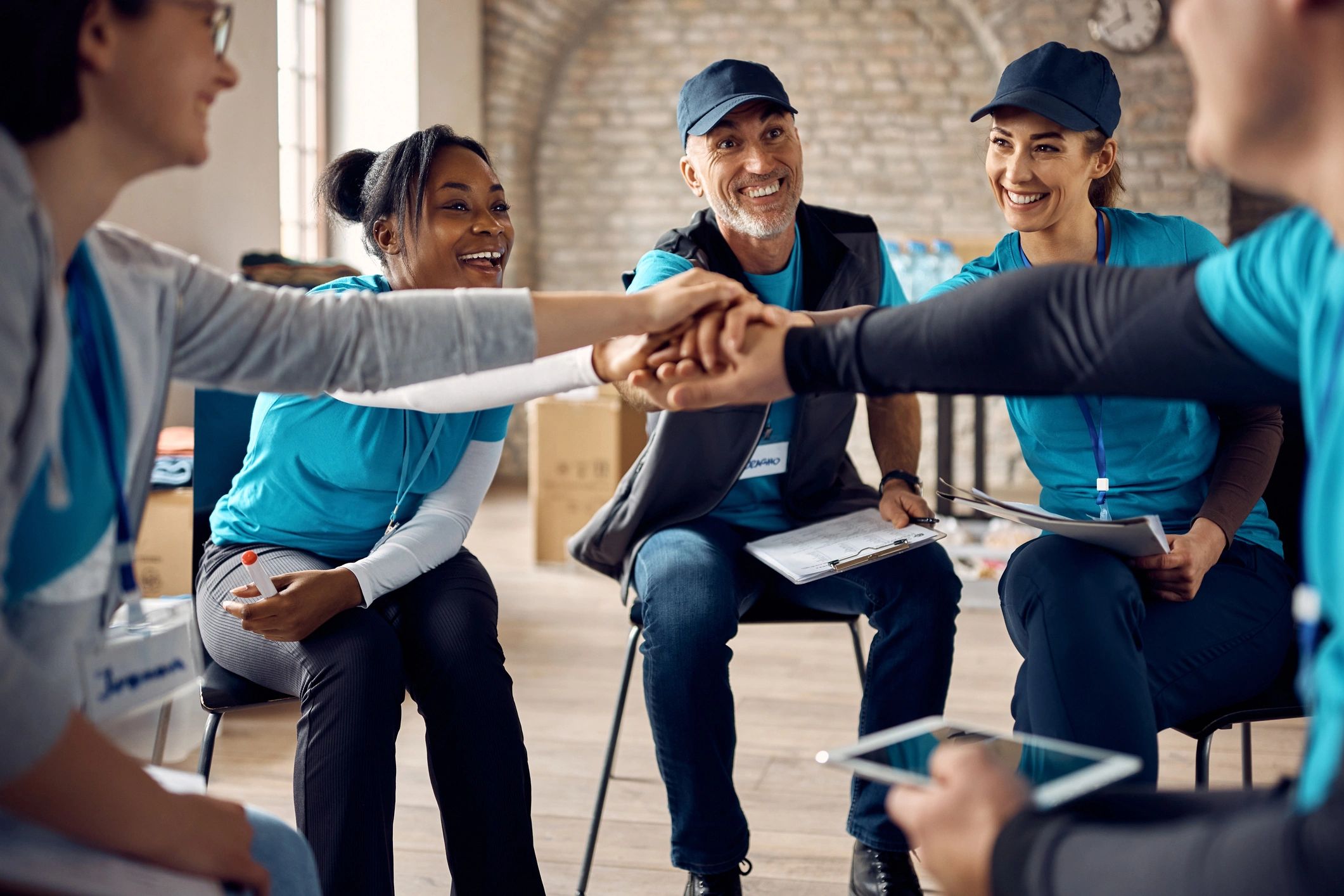 Multiracial group of happy volunteers stacking their hands